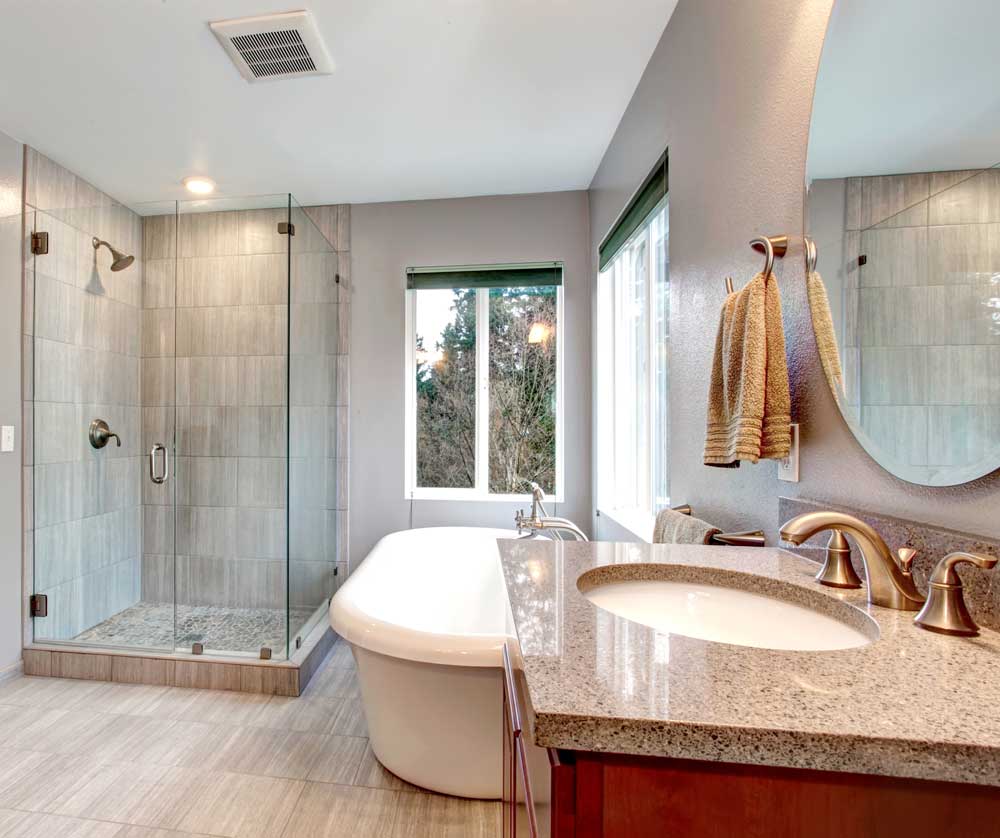 Cozy bathroom with tub, glass shower, and vanity mirror