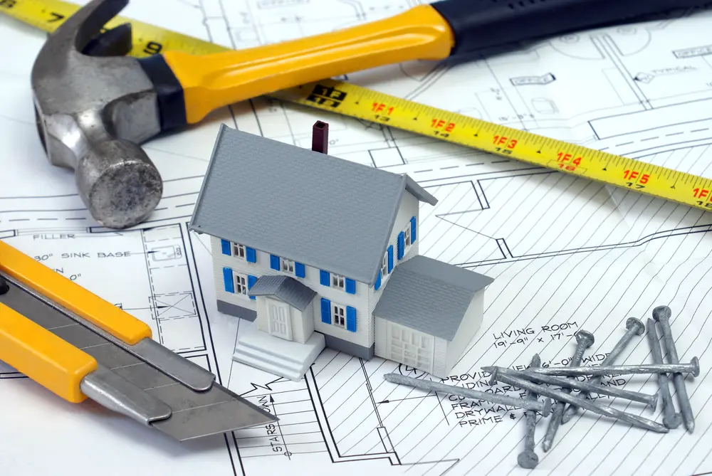 Calabasas renovation planning with construction tools, house model, and blueprints
