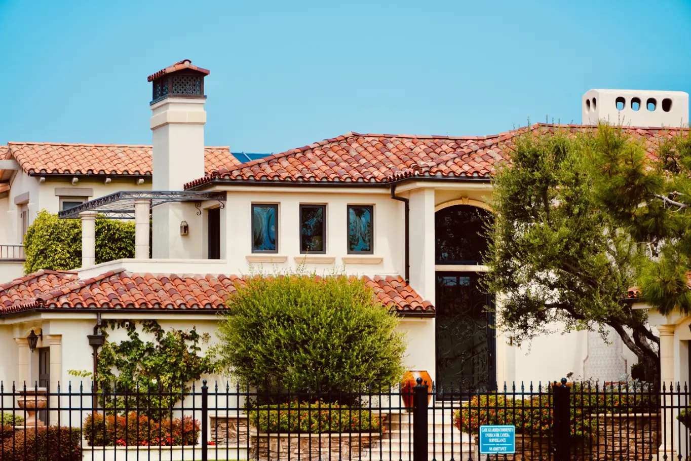 Gated Calabasas home with red brick roof and landscaped yard for home renovation